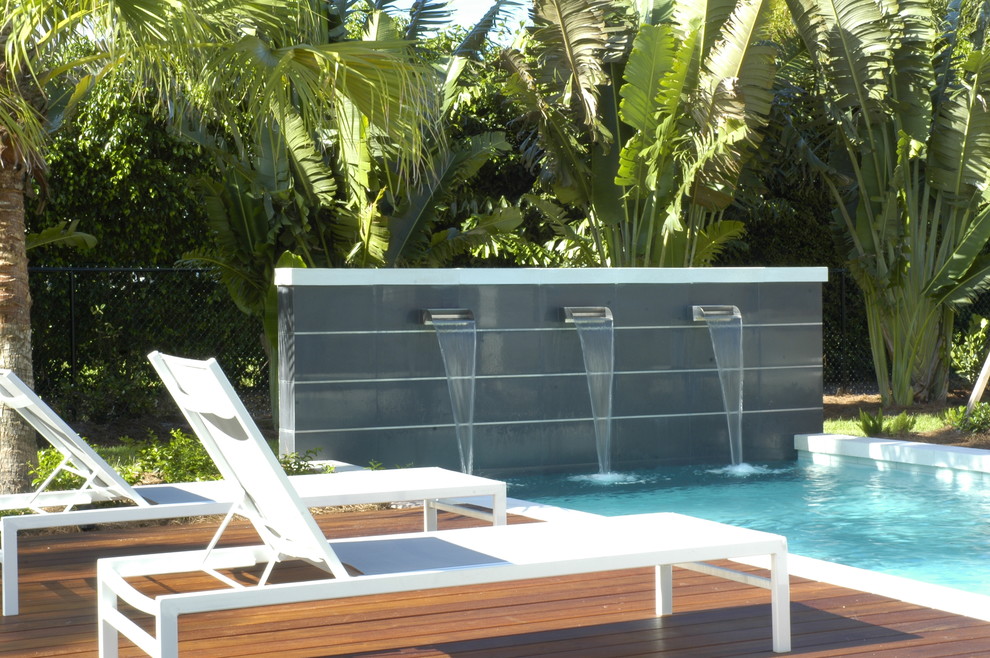 Kleines Modernes Sportbecken hinter dem Haus in rechteckiger Form mit Wasserspiel und Betonboden in Miami