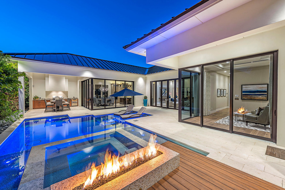 Esempio di una grande piscina design personalizzata dietro casa con piastrelle