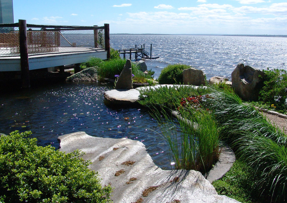 Cette photo montre une piscine naturelle et latérale asiatique sur mesure et de taille moyenne avec un point d'eau et une terrasse en bois.