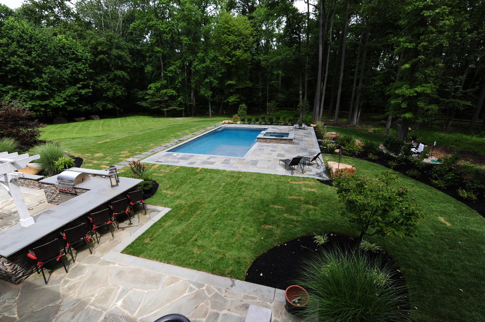 Diseño de piscinas y jacuzzis alargados tradicionales grandes rectangulares en patio trasero con adoquines de piedra natural