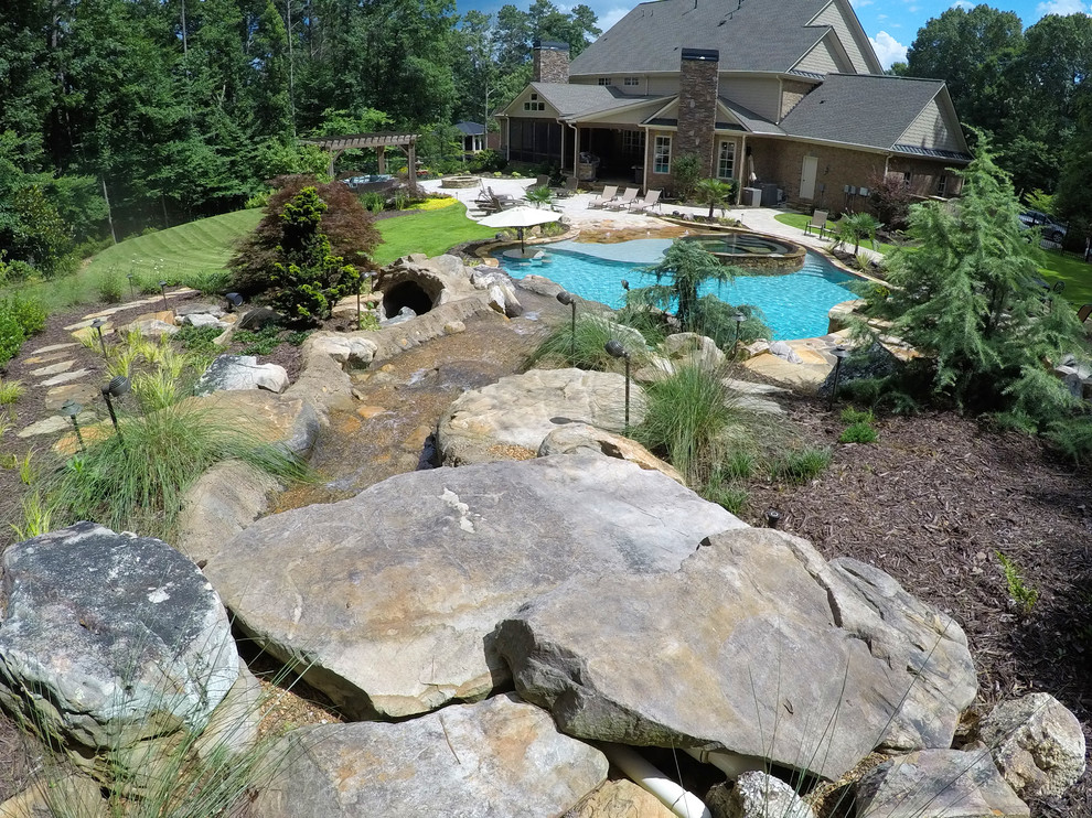 Photo of a large rustic back custom shaped natural hot tub in Atlanta with concrete paving.