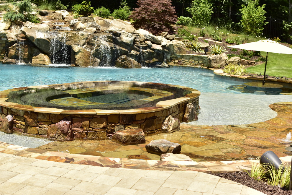 Imagen de piscinas y jacuzzis naturales rústicos grandes a medida en patio trasero con adoquines de hormigón
