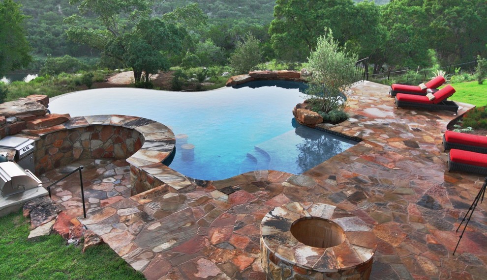 Modelo de piscina infinita clásica grande a medida en patio trasero con adoquines de piedra natural
