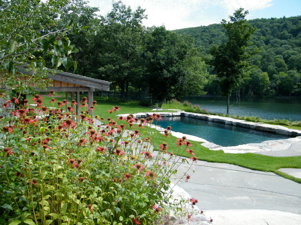 Imagen de piscina de estilo de casa de campo rectangular con adoquines de piedra natural