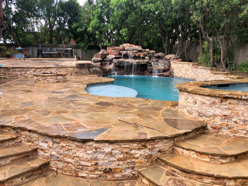 Пример оригинального дизайна: большой естественный бассейн в форме фасоли на заднем дворе в стиле рустика с перегородкой для приватности и покрытием из каменной брусчатки