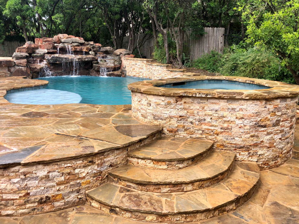 Foto de piscina natural rústica grande tipo riñón en patio trasero con privacidad y adoquines de piedra natural