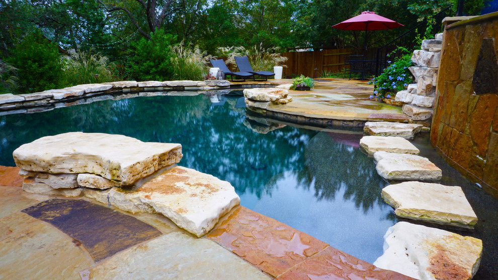 Modelo de piscinas y jacuzzis naturales de estilo americano grandes a medida en patio trasero con adoquines de piedra natural