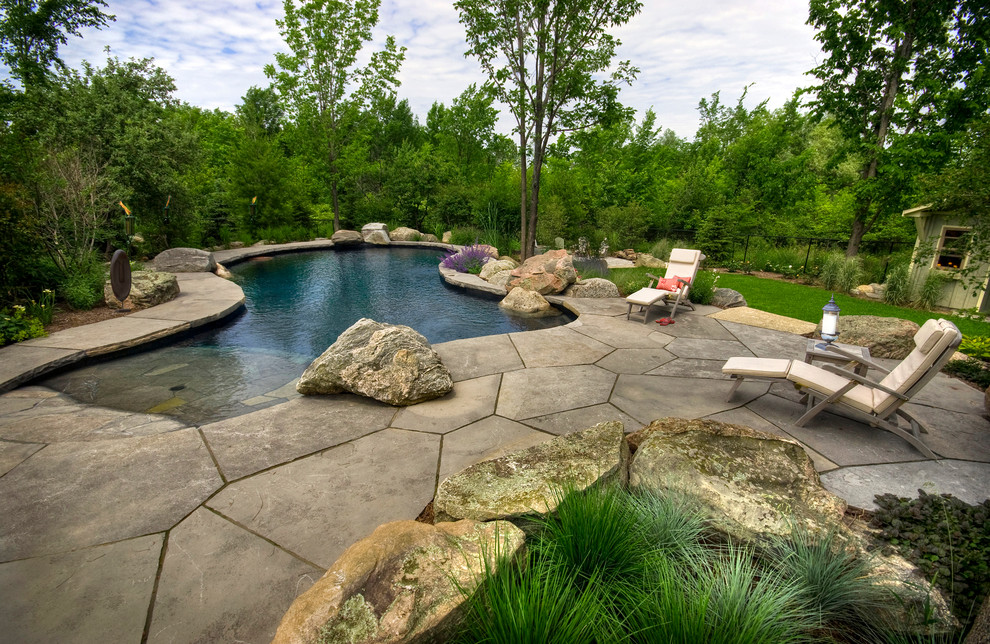 На фото: бассейн произвольной формы на заднем дворе в стиле рустика с
