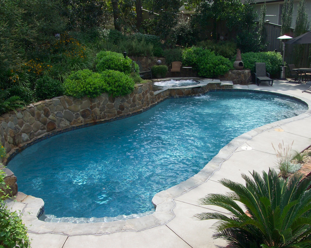 Пример оригинального дизайна: большой естественный бассейн произвольной формы на заднем дворе в стиле кантри с джакузи и покрытием из каменной брусчатки
