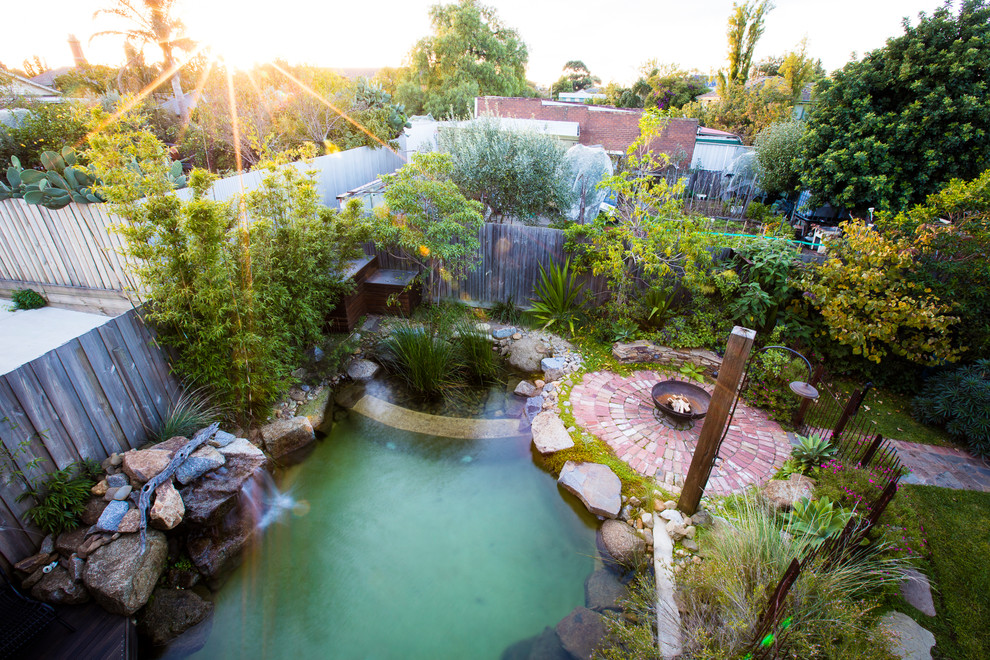 Пример оригинального дизайна: маленький естественный ландшафтный бассейн произвольной формы на заднем дворе для на участке и в саду