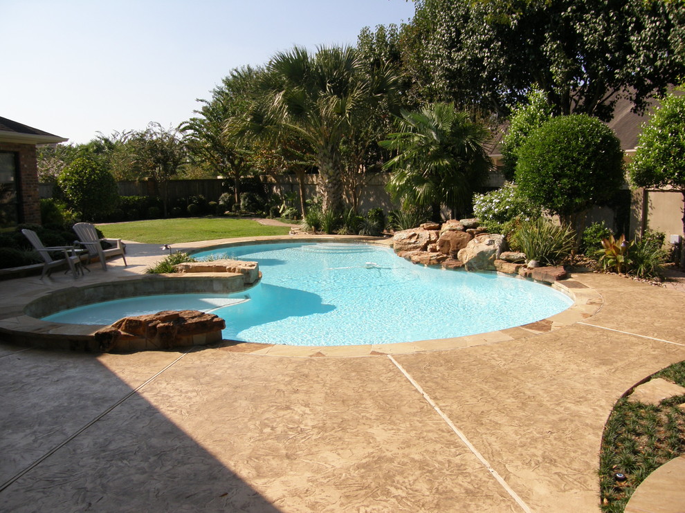 Стильный дизайн: бассейн произвольной формы на заднем дворе в стиле рустика с покрытием из декоративного бетона - последний тренд