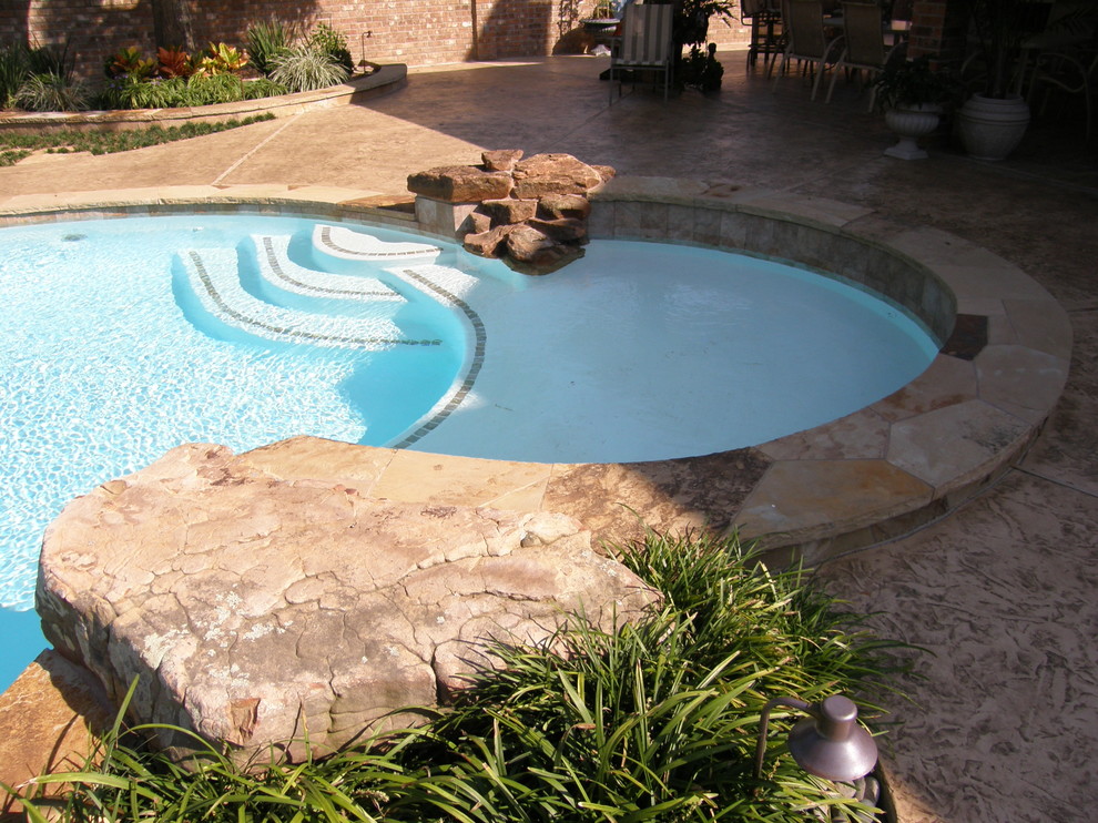 Inspiration for a rustic backyard stamped concrete and custom-shaped pool remodel in Houston