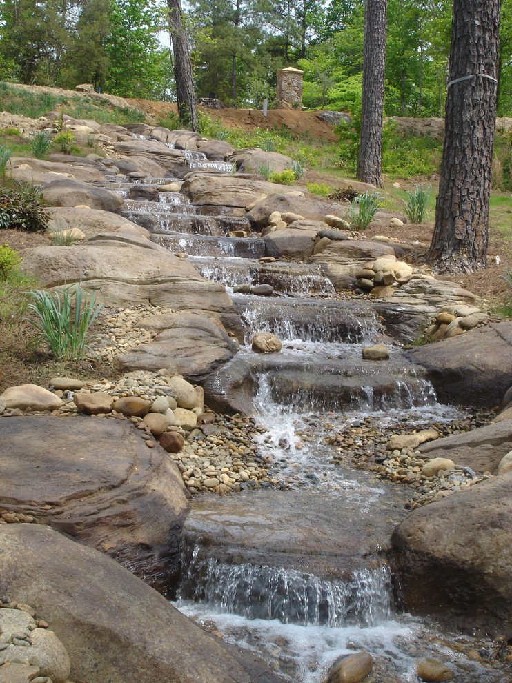 Exemple d'un très grand jardin arrière montagne avec un point d'eau et des pavés en pierre naturelle.