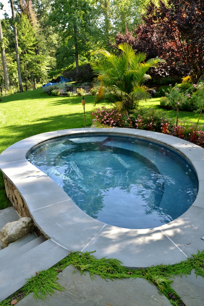 На фото: естественный бассейн среднего размера, в форме фасоли на заднем дворе в стиле рустика с джакузи и покрытием из каменной брусчатки с