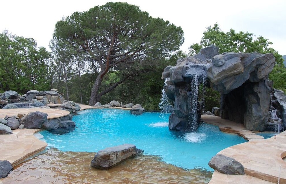 На фото: большой естественный бассейн произвольной формы на заднем дворе в классическом стиле с фонтаном и покрытием из каменной брусчатки