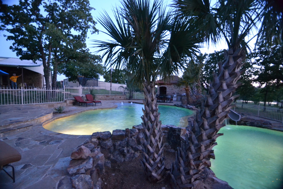 Diseño de piscina tropical de tamaño medio a medida en patio trasero con adoquines de piedra natural