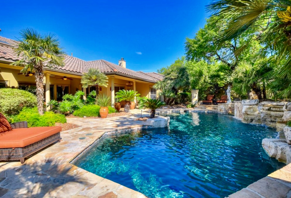Foto de piscina natural clásica grande a medida en patio trasero con entablado