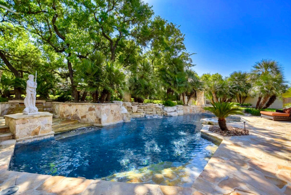 На фото: большой естественный бассейн произвольной формы на заднем дворе в классическом стиле с настилом