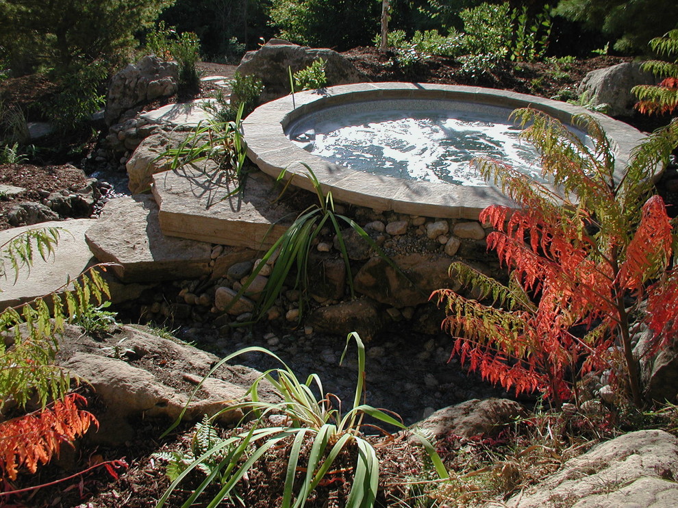 Inspiration pour une piscine naturelle et arrière chalet ronde avec un bain bouillonnant et des pavés en pierre naturelle.