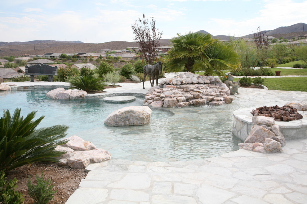 Foto di una grande piscina a sfioro infinito stile marinaro personalizzata dietro casa con fontane e pavimentazioni in pietra naturale