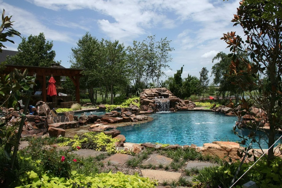 Cette image montre une piscine arrière traditionnelle rectangle avec des pavés en pierre naturelle.