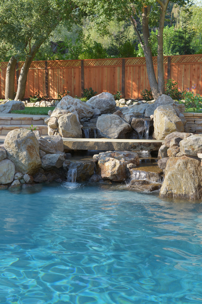 Modelo de piscina con fuente mediterránea extra grande en patio trasero con adoquines de piedra natural
