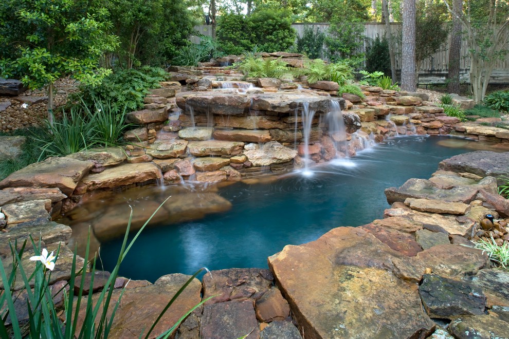 Réalisation d'une petite piscine naturelle et arrière bohème sur mesure avec un point d'eau et des pavés en pierre naturelle.