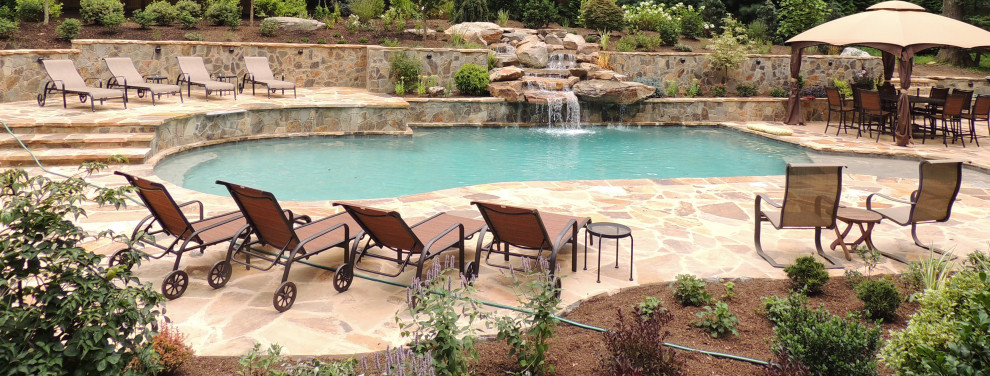 Photo of a large rustic back custom shaped swimming pool in DC Metro with natural stone paving.