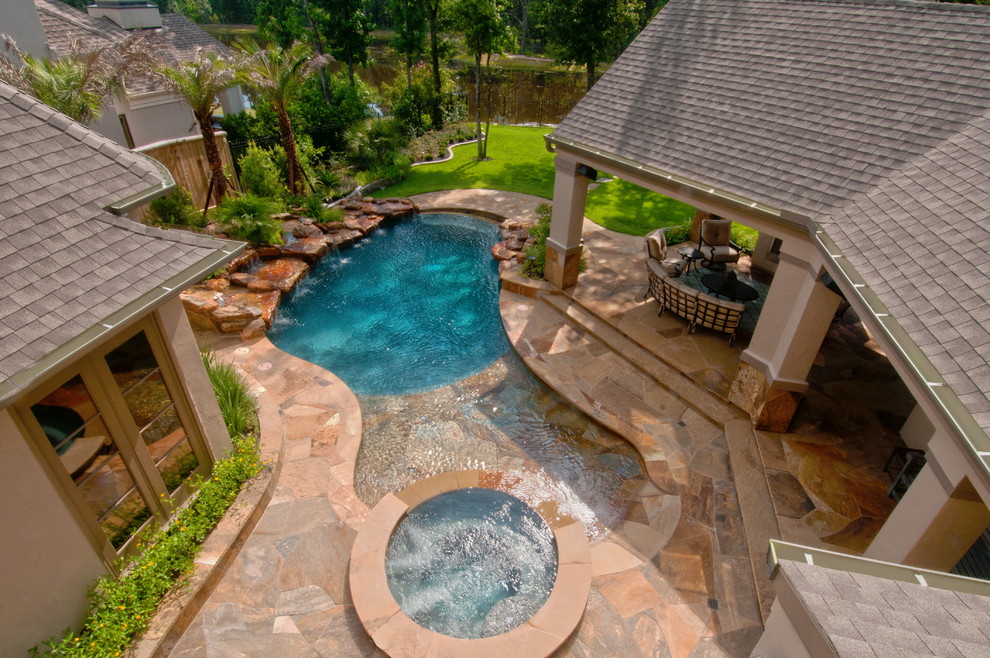 Example of a mid-sized classic backyard stone and custom-shaped lap hot tub design in Houston