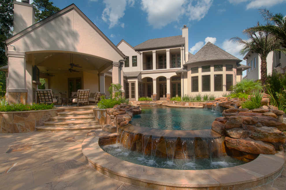 Diseño de piscinas y jacuzzis infinitos clásicos de tamaño medio a medida en patio trasero con adoquines de piedra natural
