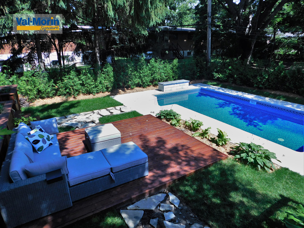 Mittelgroßer Mediterraner Pool hinter dem Haus in rechteckiger Form mit Wasserspiel und Betonboden