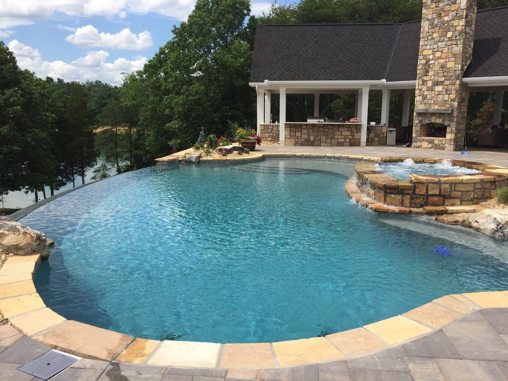 Modelo de piscinas y jacuzzis infinitos de estilo americano grandes a medida en patio trasero con adoquines de piedra natural
