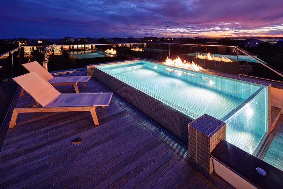 This is an example of a coastal roof rectangular above ground swimming pool in Other with decking.