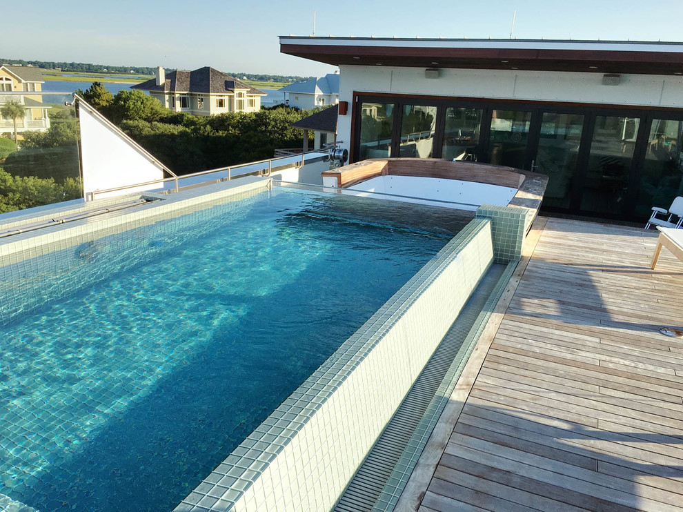 Ispirazione per una piscina a sfioro infinito minimal rettangolare sul tetto con pedane