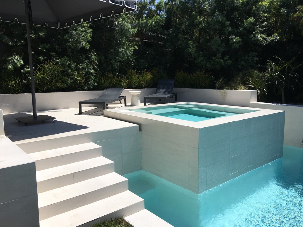Источник вдохновения для домашнего уюта: наземный, прямоугольный бассейн среднего размера на заднем дворе в современном стиле с джакузи