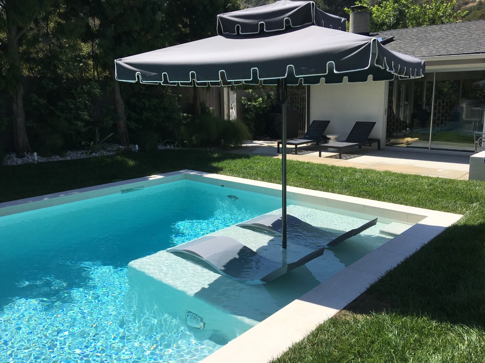 Idee per una piscina fuori terra design rettangolare di medie dimensioni e dietro casa con una vasca idromassaggio