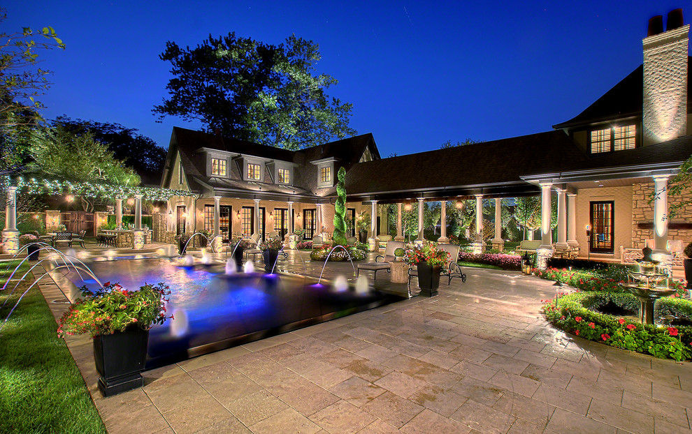 Ejemplo de casa de la piscina y piscina alargada tradicional extra grande rectangular en patio trasero con adoquines de piedra natural