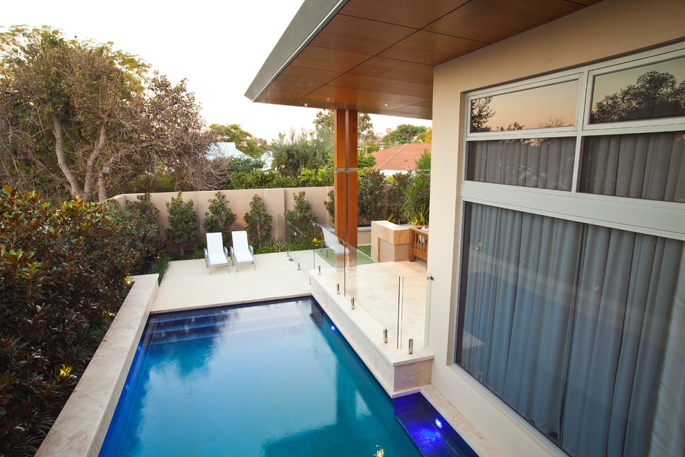 Idéer för en mellanstor modern pool på baksidan av huset, med marksten i betong
