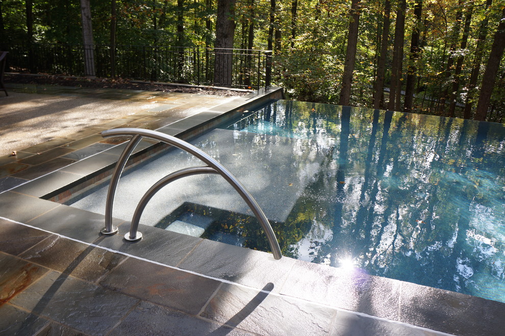 Idee per una grande piscina monocorsia minimalista rettangolare dietro casa con cemento stampato