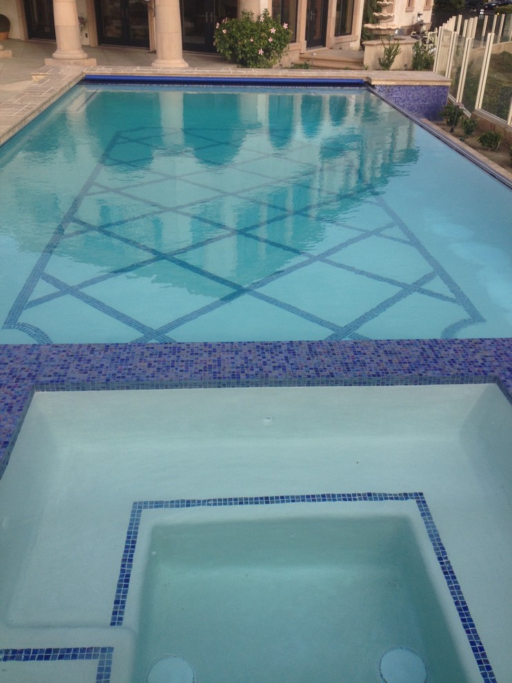 Foto di una piscina naturale moderna rettangolare di medie dimensioni e dietro casa con fontane