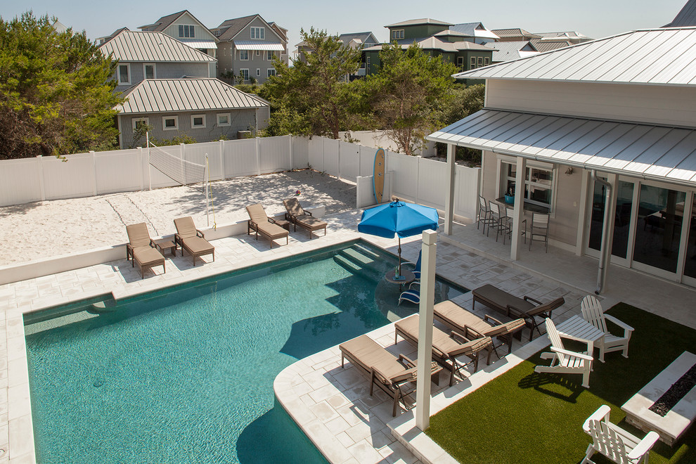 Modelo de casa de la piscina y piscina alargada costera grande en forma de L en patio trasero con suelo de baldosas
