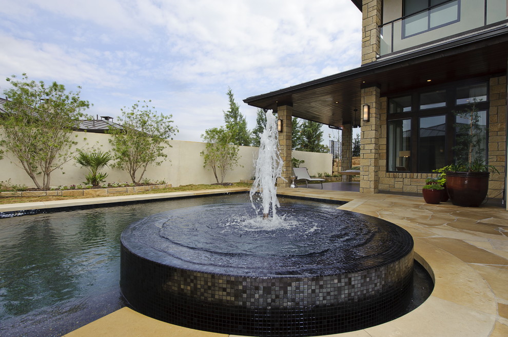 Example of a mid-sized transitional backyard stone and rectangular lap hot tub design in Austin