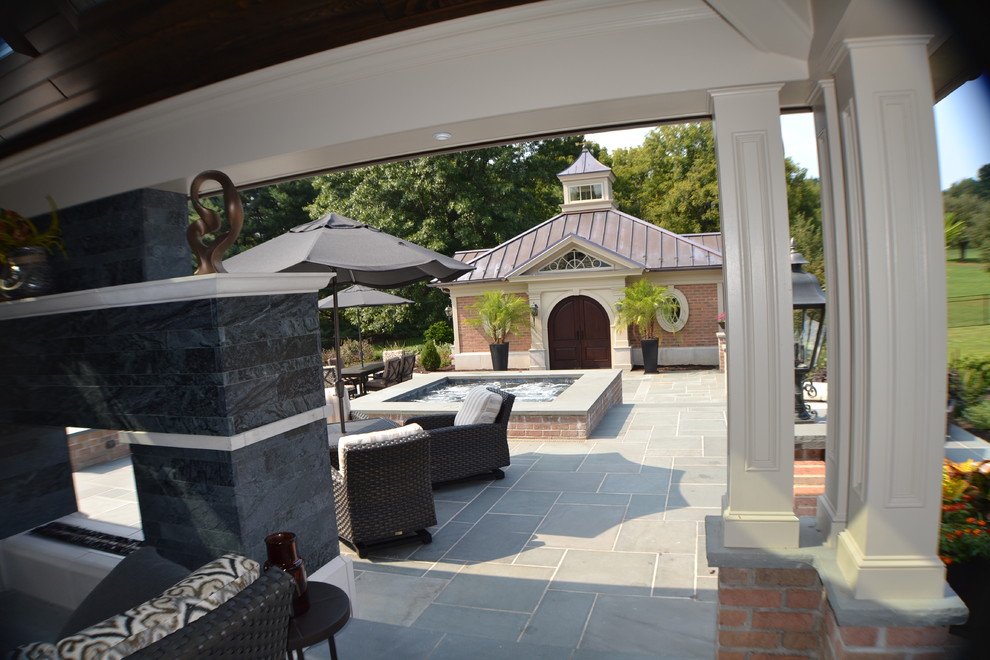 Esempio di un grande patio o portico chic dietro casa con fontane e pavimentazioni in pietra naturale