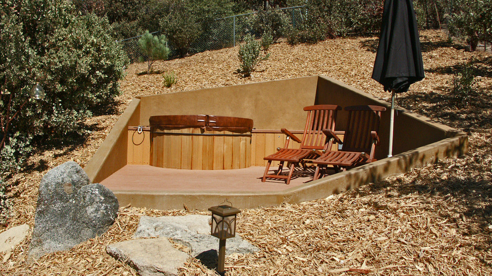 Minimalist side yard round aboveground hot tub photo with decking