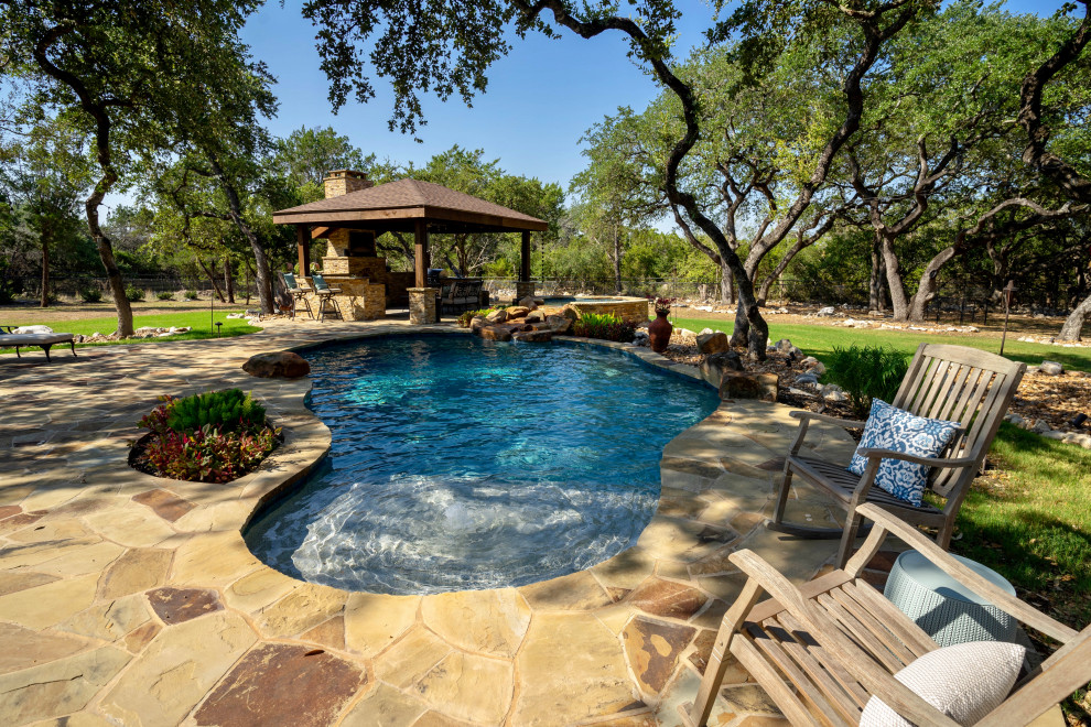 Идея дизайна: большой бассейн произвольной формы на заднем дворе в классическом стиле с домиком у бассейна и настилом
