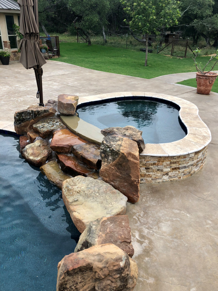 Foto di una grande piscina classica personalizzata dietro casa con fontane e lastre di cemento