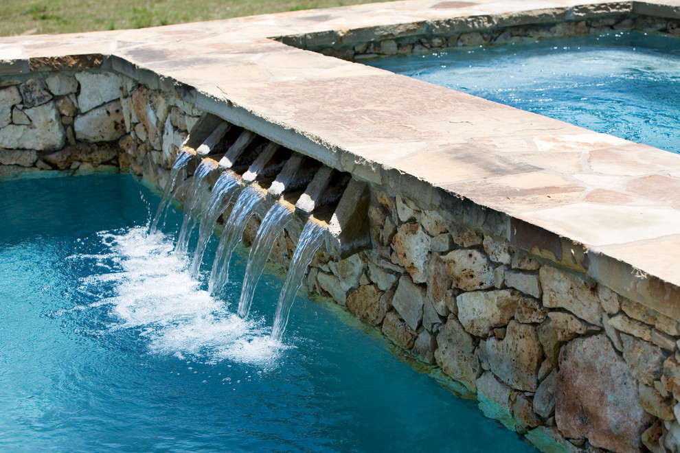 Modelo de piscinas y jacuzzis alargados campestres de tamaño medio a medida en patio trasero con adoquines de piedra natural