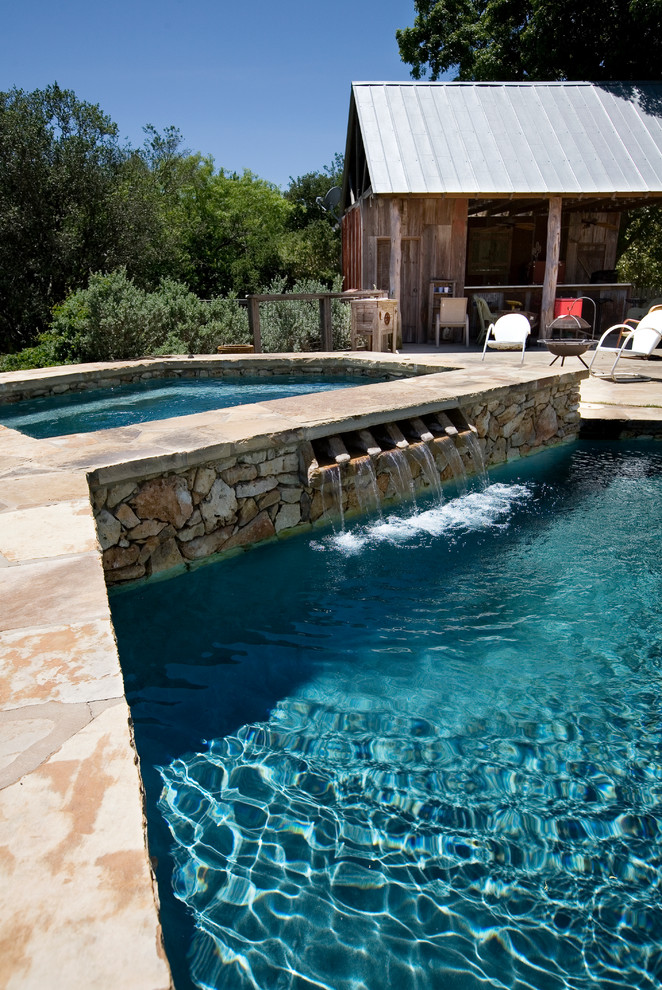 Ispirazione per una piscina monocorsia country personalizzata dietro casa e di medie dimensioni con pavimentazioni in pietra naturale e una vasca idromassaggio