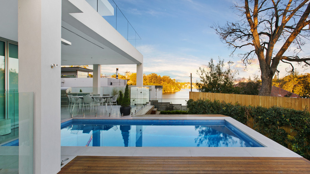 Esempio di una grande piscina monocorsia moderna rettangolare dietro casa con pedane