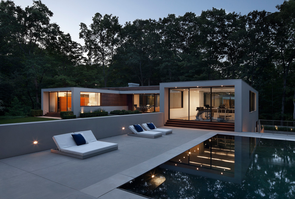 Großer Moderner Infinity-Pool hinter dem Haus in rechteckiger Form mit Betonplatten in New York